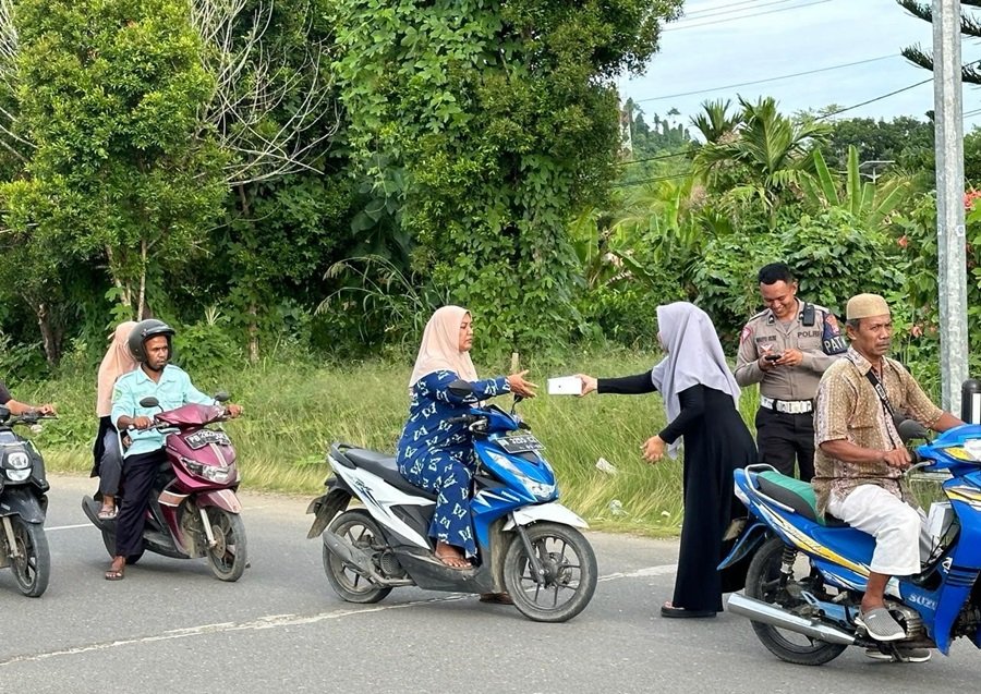 Foto: Salah seorang anggota Kelompok Pengajian Bhayangkari Polres Raja Ampat menyerahkan paket takjil ke salah seorang pelintas jalan di Bundaran Poslantas, Jalan 30 Kota Waisai, Ibukota Kabupaten Raja Ampat, Senin, (25/3/2024)/RajaAmpatNews