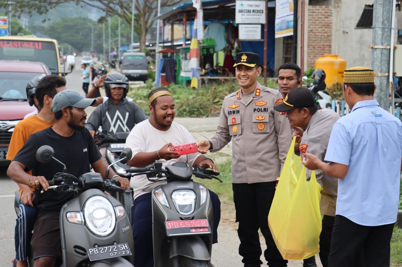 Foto: Kapolres Raja Ampat, AKBP, Edwin Parsaoran, S.IK,M.IK (tengah) menyerahkan paket takjil ke pengendara roda dua di Bundaran Poslantas, Jalan 30, Kota Waisai, Ibukota Kabupaten Raja Ampat/Penta Nila Juwita