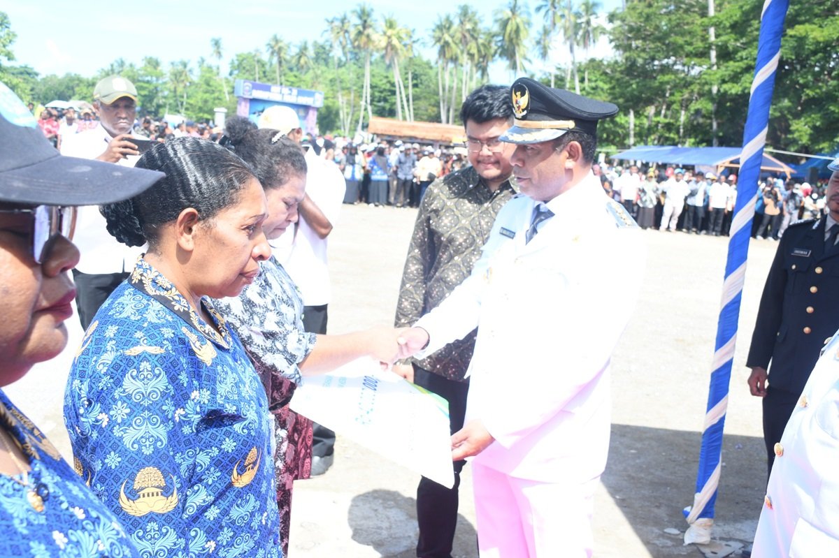 Ket: Bupati Raja Ampat, Abdul Faris Umlati, SE,M.Pd (kanan) menyerahkan santunan jaminan kematian kepada ahli waris sebagai salah satu implementasi program unggulan Raja Ampat untuk memberikan perlindungan kepada pekerja rentan/Ucok/R4News