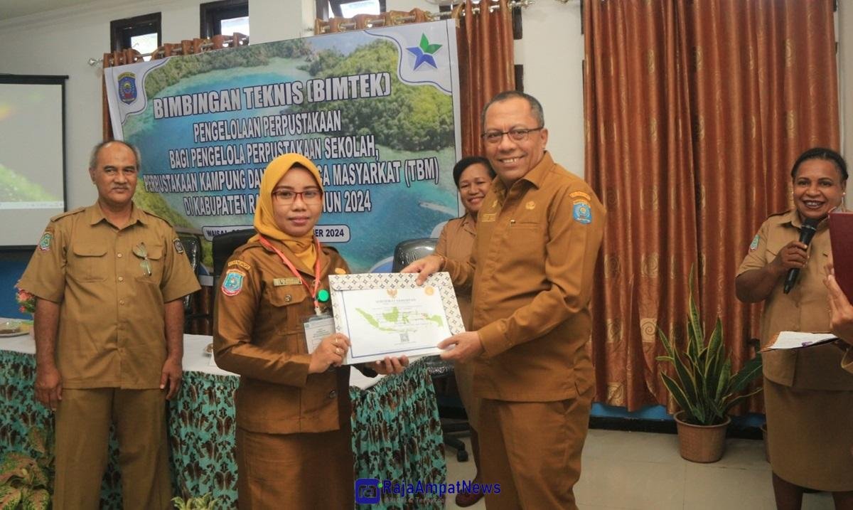 KET: Sekda Raja Ampat, Dr. Yusuf Salim, M.Si (kanan) menyerahkan sertifikat kepada perwakilan peserta Bintek Pengelola Perpustakaan (kiri) yang diwakili Pengelola Perpustakaan SMP Negeri 14 -Raja Ampat/Penta Nila Juwita