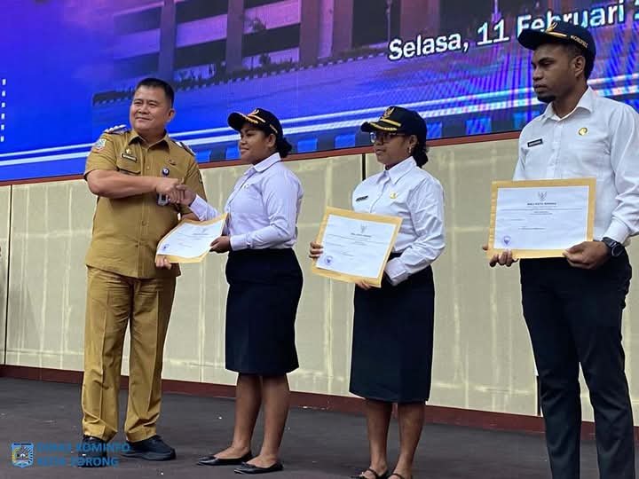 KET: Penjabat (Pj) Wali Kota Sorong, Dr. Bernhard E. Rondonuwu, S.Sos., M.Si., menyerahkan Surat Keputusan (SK) Calon Pegawai Negeri Sipil (CPNS) kepada perwakilan CPNS dalam sebuah acara di Gedung Lambert Jitmau, Selasa (11/2/2025)/FT. Dok. Kominfo Kota Sorong.