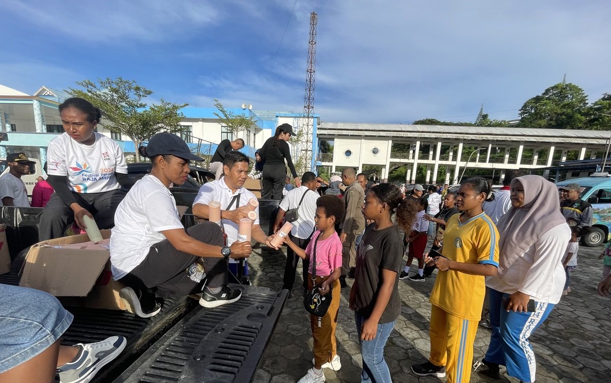 Ket: Kabag Protokol dan Komunikasi Pimpinan Setda Raja Ampat, Hj. Adam Malik (kemeja putih) memberikan tumbler kepada seorang peserta jalan sehat pada pembukaan HUT ke-22 Kabupaten Raja Ampat, Senin (5/5/2025). Pembagian tumbler tersebut sebagai kampanye mengurangi pengunaan bahan plastik sekali pakai di Raja Ampat serta mendukung Raja Ampat bersih dan bebas sampah plastik/Foto: Varuq Husain