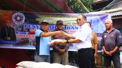 KET: Ketua DPW KKK Papua Barat Daya, Lexie Durimalang, SE., MM (kanan/kemeja putih) menyerahkan bantuan yang diterima pewakilan salah satu Kepala Desa/Kuntua (kiri) untuk selanjutnya diteruskan pada masyarakat yang terdampak banjir di kawasan Danau Tondano, Kabupaten Minahasa, Sulawesi Utara./Foto: Dok. KKK Papua Barat Daya