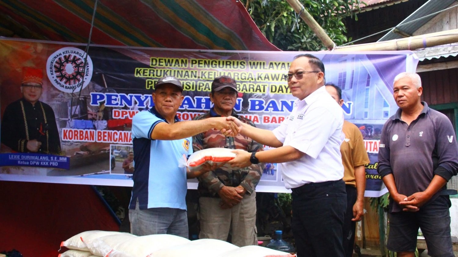 KET: Ketua DPW KKK Papua Barat Daya, Lexie Durimalang, SE., MM (kanan/kemeja putih) menyerahkan bantuan yang diterima pewakilan salah satu Kepala Desa/Kuntua (kiri) untuk selanjutnya diteruskan pada masyarakat yang terdampak banjir di kawasan Danau Tondano, Kabupaten Minahasa, Sulawesi Utara./Foto: Dok. KKK Papua Barat Daya