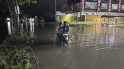 Ket: Seorang warga Kota Sorong mendorong kendaraan yang terjebak di tengah genangan banjir di depan Jupiter-Kilo 10 masuk Kota Sorong, Minggu (22/6/2025). Genanan air akibat banjir tersebut hampir meluas di sejumlah titik di Kota Sorong, Papua Barat Daya/Foto: Petrus Rabu