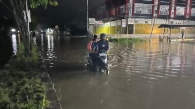 Ket: Seorang warga Kota Sorong mendorong kendaraan yang terjebak di tengah genangan banjir di depan Jupiter-Kilo 10 masuk Kota Sorong, Minggu (22/6/2025). Genanan air akibat banjir tersebut hampir meluas di sejumlah titik di Kota Sorong, Papua Barat Daya/Foto: Petrus Rabu
