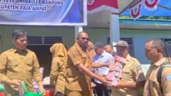 Ket: Bupati Raja Ampat, Orideko I Burdam menyerahkan ADD dan DDS ratusan juta kepada salah satu kepala kampung dalam rangkaian Acara Penyerahan Anggaran Alokasi Dana Desa (ADD) tahap II dan III tahun 2024 serta dana desa (DDs) tahap I tahun 2025 di Kampung Jefman Barat, Distrik Salawati Utara, Selasa (29/7/2025)/Foto: Petrus Rabu