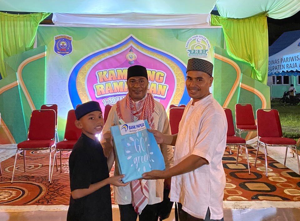 Ket: Ketua PHBI Raja Ampat. Salahudin Taesa (tengah) foto bersama dengan salah seorang panitia (kanan) saat menyerangkan hadiah lomba kepada peserta (kiri) di Kampung Ramadhan 1447 H, Pelataran Masjid Agung Waisai, Kabupaten Raja Ampat, Jumat (20/3/2026)/Foto: Dok. PHBI Raja Ampat