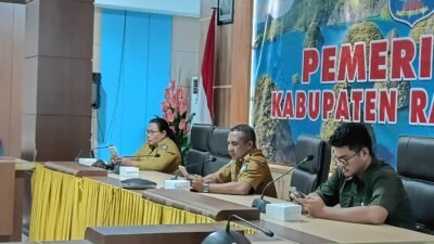 Ket: Kepala Dinas Tenaga Kerja dan Transmigrasi Kabupaten Raja Ampat, Marthen Luther R. Bartholomeus, ST., M.Si (tengah) didampingi Kepala Inspektorat Kabupaten Raja Ampat Martha Sanadi,S.Pd, M.Si (kiri) dan Kepala Kantor Cabang BPJS Ketenagakerjaan Raja Ampat Fahd Afkar Hakiki (kanan) mengikuti zoom meeting Rapat Koordinasi, Asistensi, dan Monitoring Evaluasi Capaian Universal Coverage Jaminan Sosial Ketenagakerjaan (UCJ) serta Diseminasi UCJ Award Tahun 2026 yang diselenggarakan Direktorat Jenderal Bina Pembangunan Daerah Kementerian Dalam Negeri bersama BPJS Ketenagakerjaan secara daring di Aula Wayag, Kantor Bupati Raja Ampat, Selasa (28/7/2026)/Foto: Bagian Prokopim Setda Raja Ampat